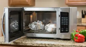 Microonde aperto con oggetti non sicuri all'interno come alluminio, uovo, vetro e contenitori di plastica