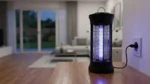 Lampada antizanzare elettrica su un tavolo in soggiorno, collegata alla presa, con insetti attorno